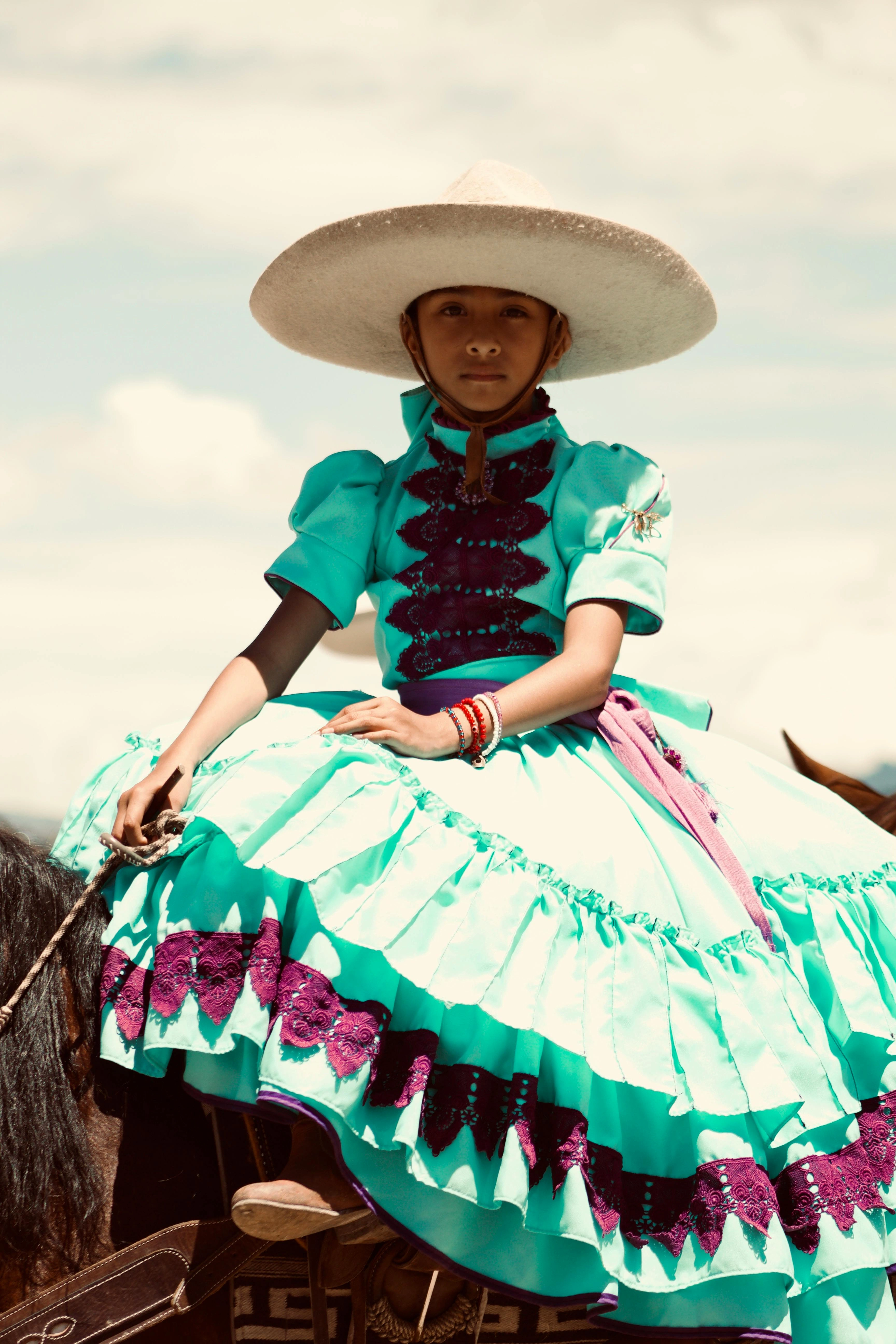 Young charra in traditional Mexican dress riding a horse